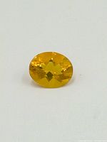 Front-facing view of the oval-faceted citrine gemstone showing the color and cut details.