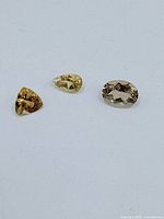 Three loose citrine gemstones showing different cuts and colors.