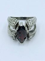 Close-up front view of sterling silver ring with marquise garnet center stone.