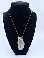 Full front view of quartz geode necklace on black display stand to show size and chain length.