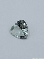 Triangle shaped faceted Spinel gemstone, light greenish color, 4.15 carats.