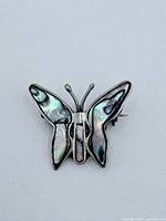 Front view of the butterfly pendant showing abalone inlay and sterling silver detailing.
