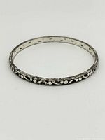 Sterling silver textured bangle bracelet shown against white background for detailed view.