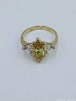 Top-down view of the ring showing the marquise-shaped citrine center stone and two clear triangular side stones.