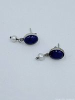 Pair of sterling silver earrings with teardrop labradorite stones and small pearl drops, front view.