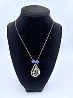 Full view of the necklace displayed on a black bust, showing the pendant and beads on the chain.