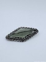 Front view of sterling silver brooch with large faceted smoky quartz gemstone and rope-like detailed frame.