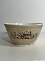 Front view of ivory Pyrex mixing bowl with detailed brown Forest Fancies mushroom design around exterior.