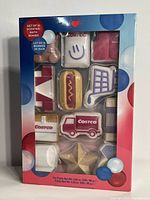 Front view of the 12 scented bath bombs in original packaging showing various shaped bath bombs including shopping cart and hot dog designs.