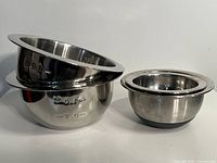 Four stainless steel mixing bowls shown nested and separate, highlighting sizes and nesting feature.