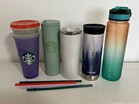 Shows full set of 3 travel mugs, 1 water bottle, and 4 Starbucks cups with lids and straws.