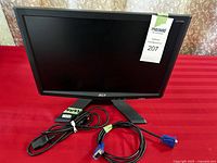 Full view of Acer X173W monitor on stand with power and VGA cables in front.