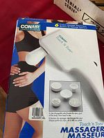 Photo of Conair Touch 'n Tone handheld massager packaging showing device and interchangeable attachments