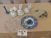 Full lot of blue kitchen items on table, showing platters, tea cups, vases, mug