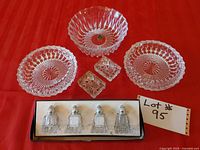 All items arranged on red cloth including bowls, ashtrays, and salt and pepper shakers with lot number shown