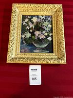 Full view of floral paintings showing ornate cream and gold frame on red background