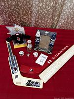 Full lot arranged on red cloth table cover showing frames, mini jersey, mini mugs, pins, and mini sticks