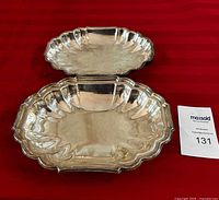 Top view of silver plated serving dish with lid removed, showing interior and scalloped edges.