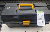 Closed black plastic toolbox with yellow handle and latch on white surface