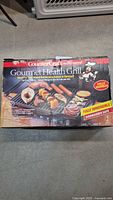 Box front shows Charlescraft CounterCraft Gourmet Health electric grill, fat-free grilling design with food images on grilling surface.