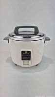 Full frontal view of the National electric rice cooker showing stainless steel body, black plastic lid handle and side handles.