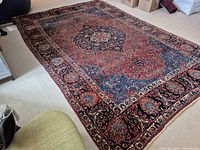 Overall view of rug laid flat showing full medallion pattern and border
