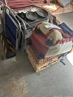 Photo shows camping chairs, picnic baskets, and a Mickey Mouse backpack on top of baskets, slow cookers in background