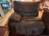 Front and top angled view of brown suede recliner chair showing seat cushions and armrest.