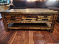 Front view showing six drawers with metal handles and open shelf below on dark wood coffee table.