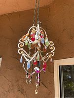 Front and side views of eclectic small hanging chandelier with multicolor teardrop-shaped pendants and bead accents on a white/cream metal frame.