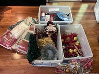 Plastic bins showing organized Christmas tree bulbs and ornaments alongside holiday pillows and holiday lights.