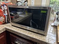 Front view of Kenmore stainless steel microwave showing digital display and keypad.