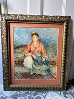 Full view of framed impressionist print showing seated woman in traditional attire with ornate carved wooden frame.