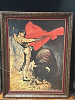 Framed matador lithograph with bull, showing details of the framed print and wooden frame.