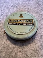Top view of round tobacco tin with Capstan Navy Cut Medium branding and W.D. & H.O. Wills Bristol & London inscription.