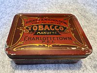 Top view of the tobacco tin showing Hickey & Nicholson branding and decorative design