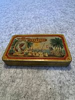 Top and angled view of Khedive tobacco tin showing illustration and label
