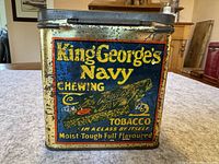 Front side close-up showing detailed text and graphic of King George's Navy Chewing Tobacco tin with wear and rust spots.