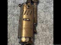 Photo showing front view of metal lighter with Wico Switzerland Kline engraved on surface.