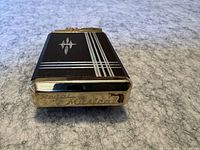 Bottom view of the lighter showing the engraving 'Royal Musical' and a lion emblem on gold plating.