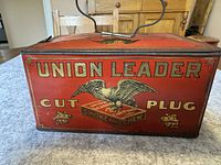 Front view of red Union Leader Cut Plug tobacco tin featuring eagle graphic and text