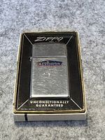 Front view of the Zippo lighter in original box, showing the B.F. Goodrich logo on the lighter and box details.