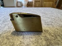 Side view of the vintage metal lighter showing the ignition wheel and flip-top design.