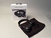 Bang & Olufsen H9 3rd Generation headphones displayed with box and accessories on a flat surface.