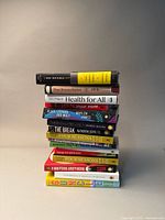 Stack of 12 books featuring varied titles including 'Invisible City', 'True Reconciliation', 'Health for All', and '8 Sisters Brothers'. Covers indicate themes of queer and Canadian literature.
