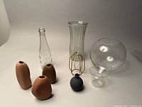 Full set of 9 vases including ceramic and glass showing variety of colors and shapes