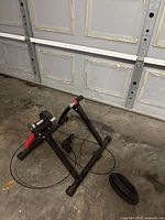 Photo of the black metal stationary bike mount with resistance unit shown from left side.
