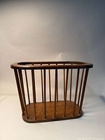 Image of vintage brown wooden magazine rack with vertical wooden rods, showing front and side views.
