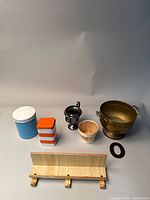 Front view showing a variety of metal and wood decorative items including containers, trophy, bucket, basket and wall hook.