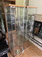 Front view of two adjacent cabinets showing full height, shelves, and wood framing.